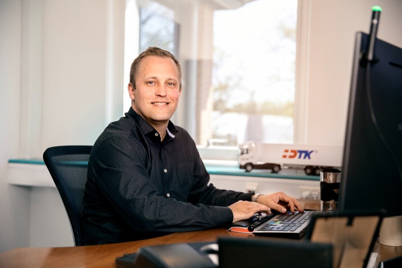 Kontormedarbeider sitter ved datamaskinen og jobber med timeregistrering og vaktplan i et digitalt workforce management-system.