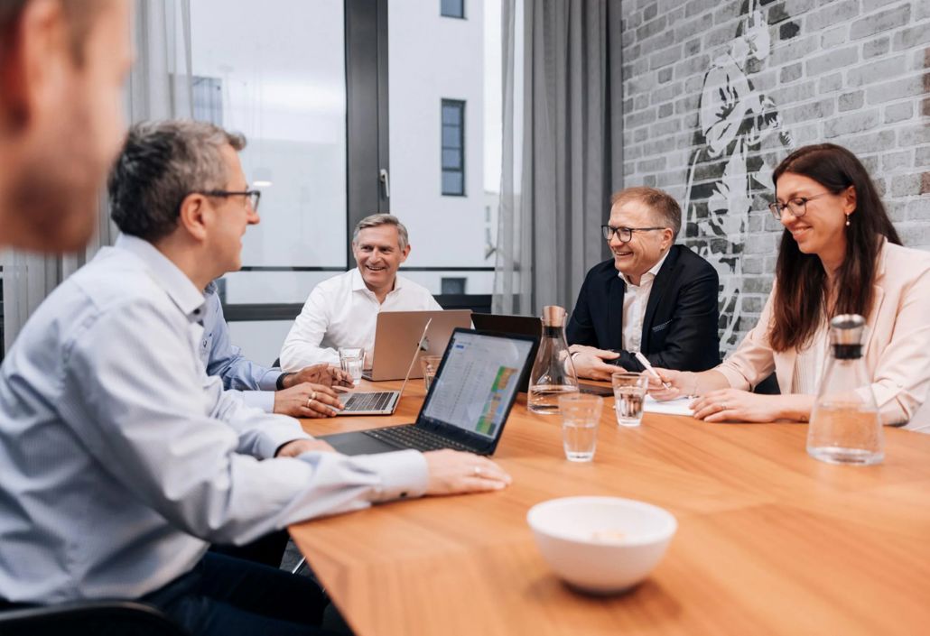 Lederteam i et strategimøte som gjennomgår bemanningsytelse og innsikt fra vaktplanlegging for å forbedre operasjonell planlegging og ressursallokering.